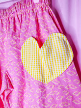 Load image into Gallery viewer, Pink pants with yellow heart design on a pink background