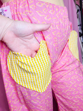 Load image into Gallery viewer, Close-up of pink fabric with yellow pop tarts and a hand inside a yellow gingham heart pocket