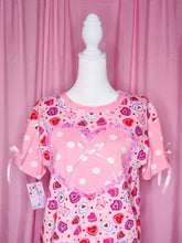 Load image into Gallery viewer, Pink shirt with heart cake patterns on a mannequin against a pink background