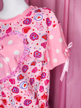 Load image into Gallery viewer, Pink boxy top with heart cake and polka dot patterns on a mannequin against a pink curtain.