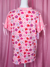 Load image into Gallery viewer, Pink boxy top with heart cake pattern on a mannequin against a pink background