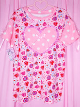 Load image into Gallery viewer, Pink t-shirt with heart and polka dot pattern on a pink background