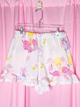 Load image into Gallery viewer, Ruffle shorts with fairy design on a pink background