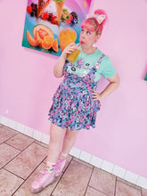 Load image into Gallery viewer, woman modeling t-shirt with miss alphabet logo, pillows, and pink 90s barbie boombox print