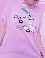Load image into Gallery viewer, woman modeling t-shirt with miss alphabet logo, pillows, and pink 90s barbie boombox print