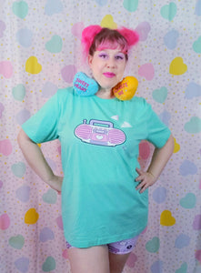 woman wearing mint green t-shirt with pink barbie boombox