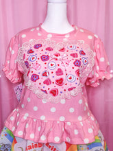 Load image into Gallery viewer, Pink polka dot dress with colorful heart pattern on a mannequin against a pink curtain background.