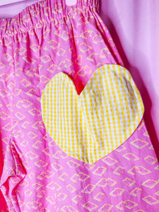 Pink pants with yellow heart design on a pink background
