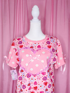 Pink shirt with heart cake patterns on a mannequin against a pink background