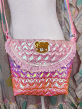 Load image into Gallery viewer, Pink and purple quilted bag with a teddy bear emblem on a colorful background