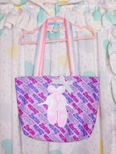 Load image into Gallery viewer, A pastel pink and purple Barbie-themed tote bag with a white Barbie doll silhouette, hanging from a pink hanger against a ruffled white curtain backdrop with pastel accents.