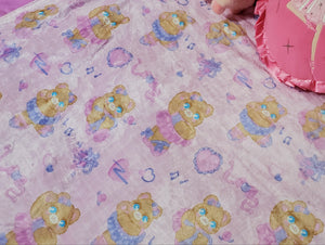 bed with pink ballerina bear blanket and barbie pillows