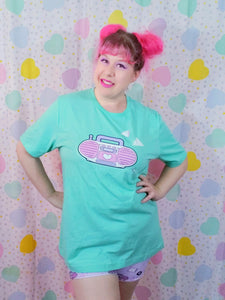 woman wearing mint green t-shirt with pink barbie boombox