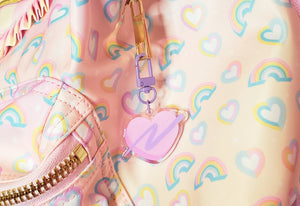 pink swoosh heart keychain with rainbow background