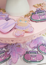 Load image into Gallery viewer, various pastel colored keychains on a pink dessert tray