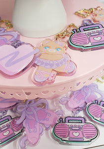 various pastel colored keychains on a pink dessert tray