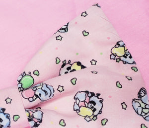 pink hair bow with a 90's style print of koalas, panda, hearts, and stars.