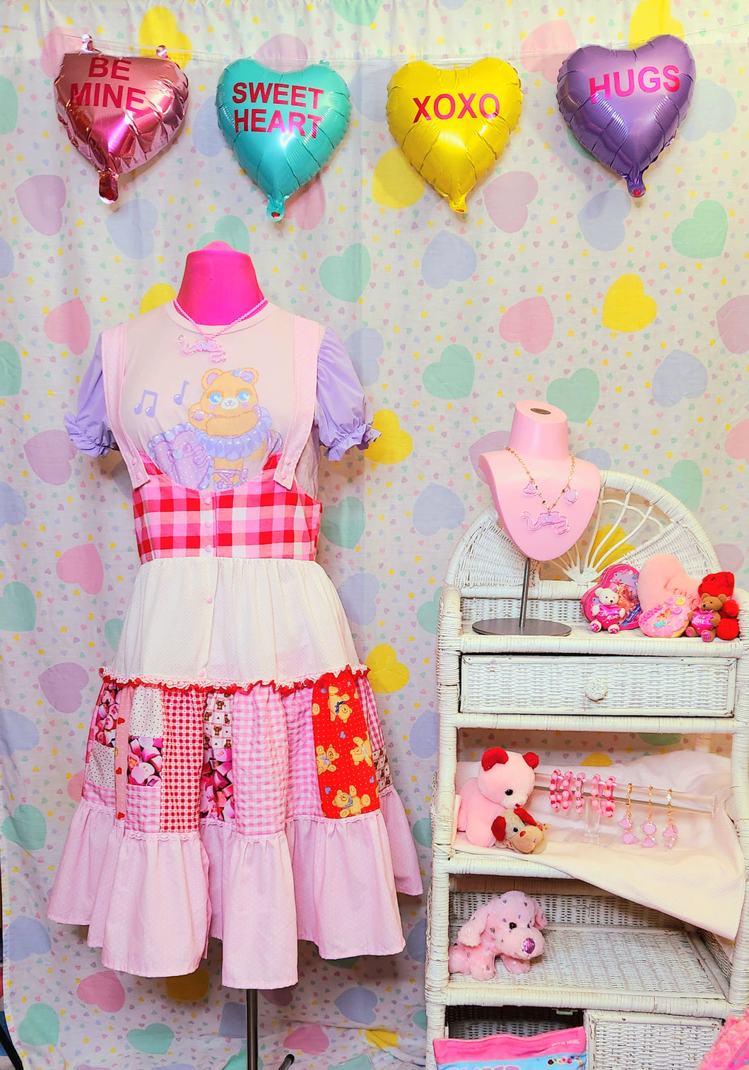 Valentine's themed patchwork jumperskirt on a mannequin against a pastel heart backdrop