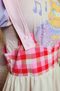 closeup of pink heart snap closure on jumperskirt straps