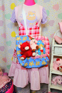 Valentine's themed patchwork jumperskirt on a mannequin with a patchwork valentine plush tote bag, against a pastel heart backdrop