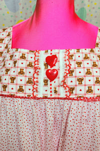 closeup of red heart button detail on red plaid teddy bear yoke of nightie dress