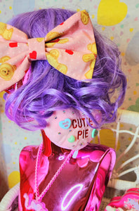 Pink Valentine's Day hair bow with hearts and teddy bears, on a lavender haired shiny pink mannequin bust