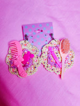 Load image into Gallery viewer, pink and yellow crochet flower earrings with barbie brushes, combs, a perfume bottle, sprinkled with rhinestones