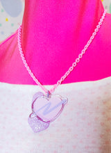 Load image into Gallery viewer, pink enamel chain necklace with pink and lavender glitter swoosh heart acrylic pendant on pink mannequin and heart print shirt