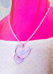 pink enamel chain necklace with pink and lavender glitter swoosh heart acrylic pendant on pink mannequin and heart print shirt