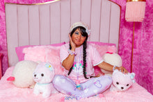 Load image into Gallery viewer, latina woman modeling pastel dog print clothing and t-shirt on a bed in pink room