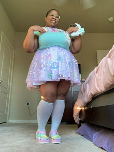 african american nonbinary wearing a mint green top with layered heart skirts